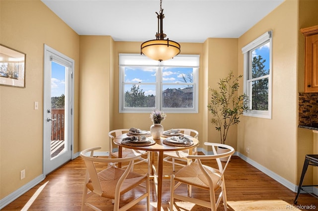 dining area featuring baseboards and light wood-style flooring