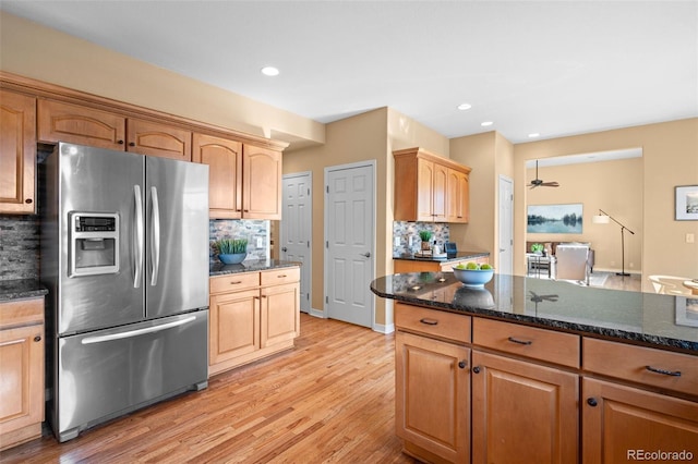 kitchen featuring dark stone countertops, light wood finished floors, recessed lighting, stainless steel refrigerator with ice dispenser, and tasteful backsplash