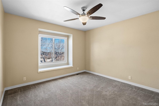 spare room with baseboards, carpet, and a ceiling fan