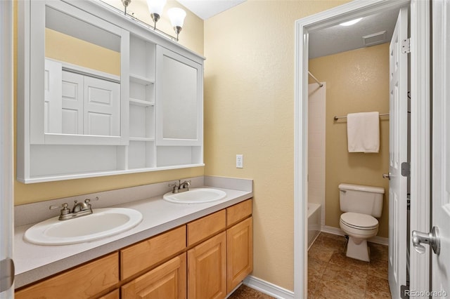 full bathroom featuring a sink, baseboards, toilet, and double vanity