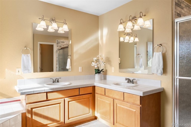 full bathroom featuring double vanity, a stall shower, and a sink