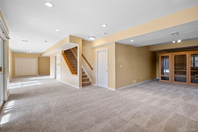 unfurnished room with visible vents, recessed lighting, baseboards, light colored carpet, and stairs