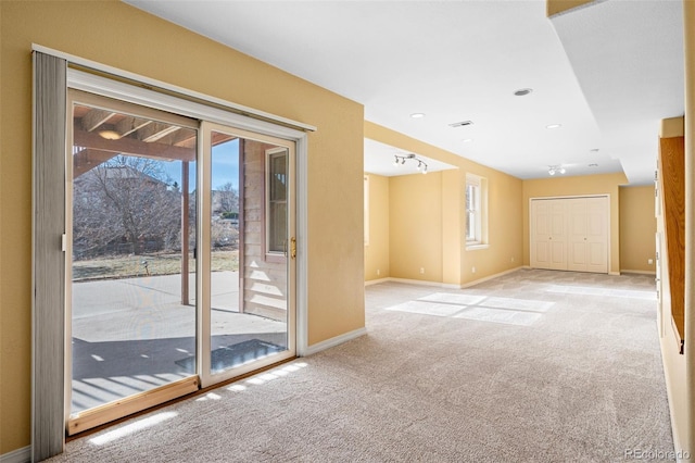 carpeted spare room with visible vents and baseboards