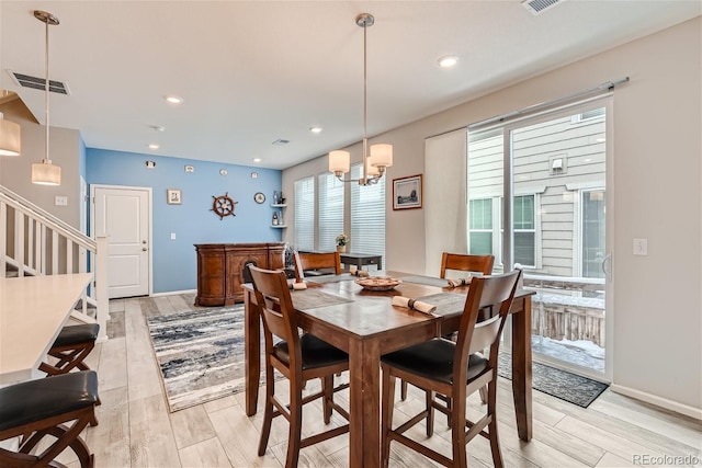 dining space featuring light hardwood / wood-style flooring and an inviting chandelier