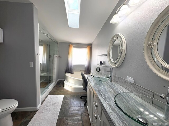 29 Granada Ct, Silver Cliff, CO 81252 - bathroom featuring a stall shower, a garden tub, baseboards, double vanity, and stone tile flooring