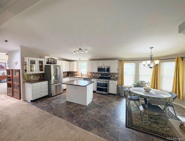 29 Granada Ct, Silver Cliff, CO 81252 - kitchen featuring appliances with stainless steel finishes, dark countertops, a chandelier, and tasteful backsplash