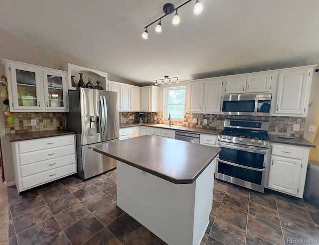 29 Granada Ct, Silver Cliff, CO 81252 - kitchen with stainless steel appliances, dark countertops, a sink, backsplash, and white cabinetry