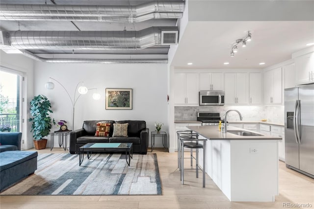 3401 Arapahoe Ave Unit 105, Boulder, CO 80303 - kitchen with stainless steel appliances, a sink, open floor plan, white cabinetry, and tasteful backsplash