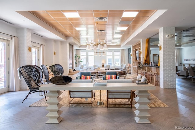 3401 Arapahoe Ave Unit 105, Boulder, CO 80303 - dining space featuring decorative columns, a chandelier, healthy amount of natural light, and a tray ceiling