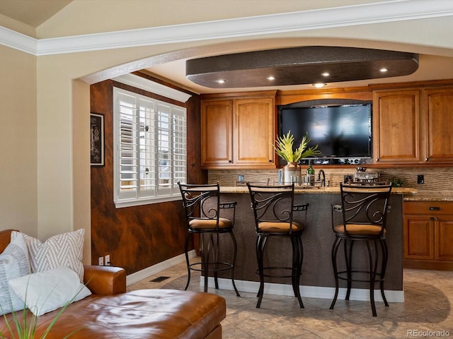 10954 W 100th Way, Broomfield, CO 80021 - indoor wet bar featuring decorative backsplash, crown molding, and recessed lighting