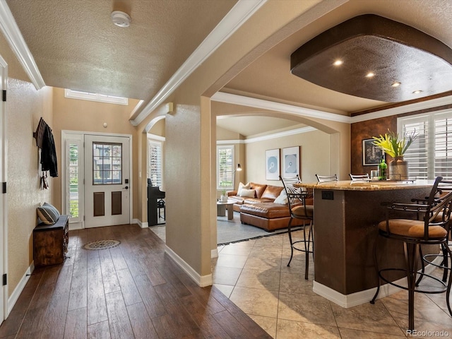 10954 W 100th Way, Broomfield, CO 80021 - entrance foyer with hardwood / wood-style floors, arched walkways, a textured ceiling, ornamental molding, and a raised ceiling