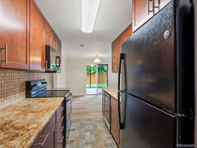 10954 W 100th Way, Broomfield, CO 80021 - kitchen with black appliances, backsplash, brown cabinets, light stone counters, and a textured ceiling