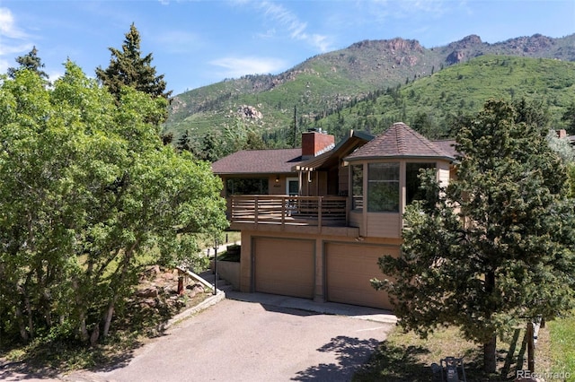 4665 Fox Rd, Cascade, CO 80809 - view of front of home with a mountain view, an attached garage, a chimney, and a balcony