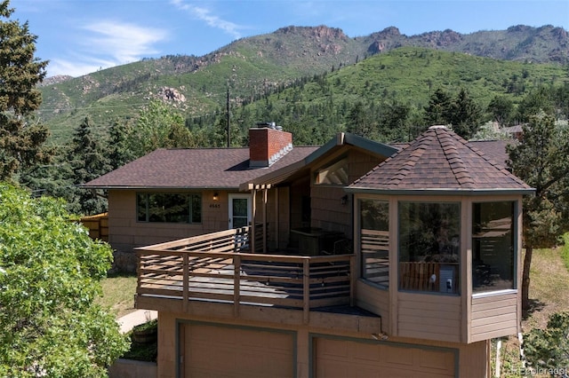 4665 Fox Rd, Cascade, CO 80809 - rear view of property featuring an attached garage, a mountain view, and a chimney