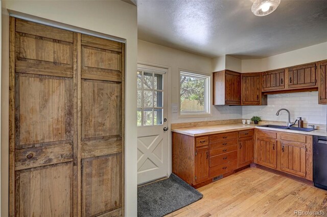 4665 Fox Rd, Cascade, CO 80809 - kitchen featuring light wood-style floors, light countertops, decorative backsplash, and brown cabinets