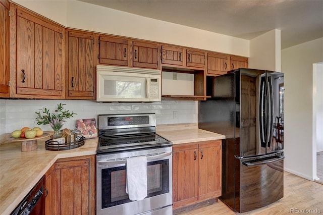 4665 Fox Rd, Cascade, CO 80809 - kitchen with white microwave, electric stove, freestanding refrigerator, and light countertops