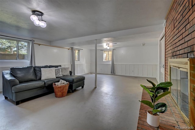 4665 Fox Rd, Cascade, CO 80809 - living area featuring finished concrete floors, wainscoting, and a fireplace