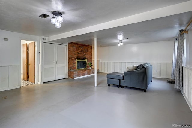 4665 Fox Rd, Cascade, CO 80809 - living room featuring finished concrete floors, a fireplace, and wainscoting
