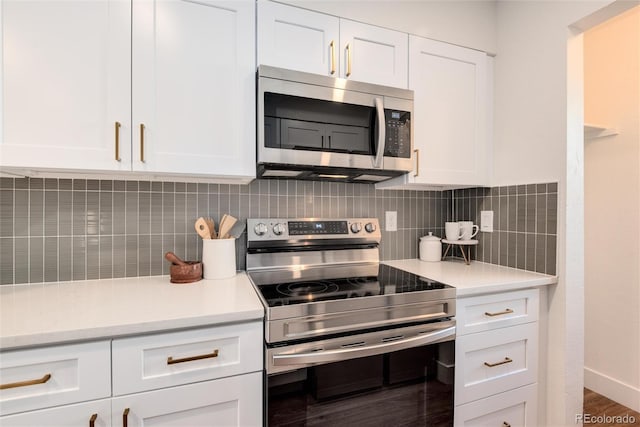 kitchen with tasteful backsplash, white cabinetry, hardwood / wood-style flooring, and appliances with stainless steel finishes