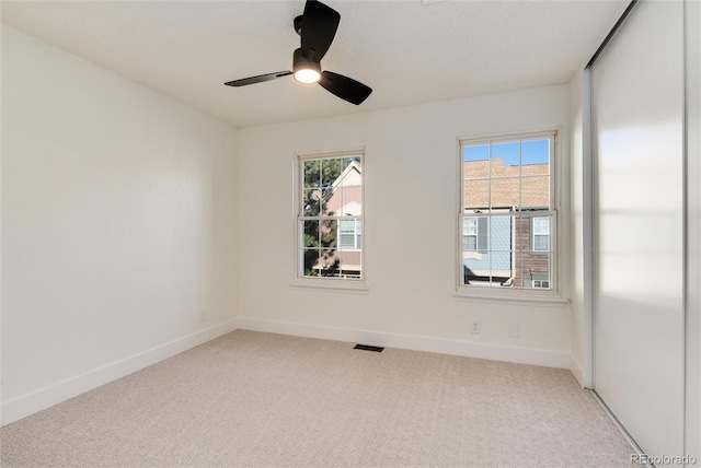 unfurnished room with ceiling fan, carpet, and a healthy amount of sunlight