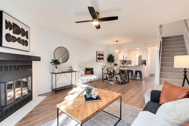 living room with ceiling fan and light wood-type flooring