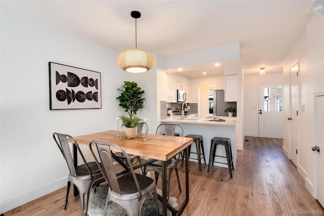 dining space featuring sink and light hardwood / wood-style flooring