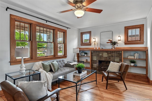 3611 N Vine St, Denver, CO 80205 - living area with healthy amount of natural light, light wood-type flooring, a ceiling fan, crown molding, and a brick fireplace