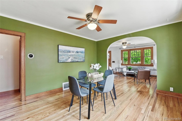 3611 N Vine St, Denver, CO 80205 - dining room featuring arched walkways, light wood finished floors, a ceiling fan, crown molding, and baseboards