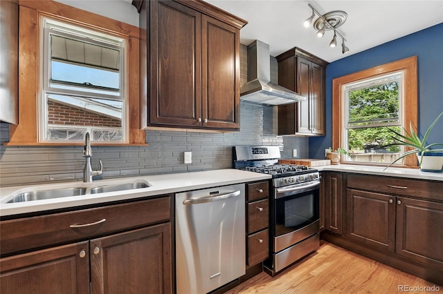 3611 N Vine St, Denver, CO 80205 - kitchen featuring appliances with stainless steel finishes, wall chimney exhaust hood, a sink, light countertops, and tasteful backsplash