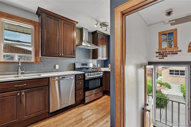 3611 N Vine St, Denver, CO 80205 - kitchen featuring wall chimney range hood, stainless steel appliances, a sink, light countertops, and tasteful backsplash