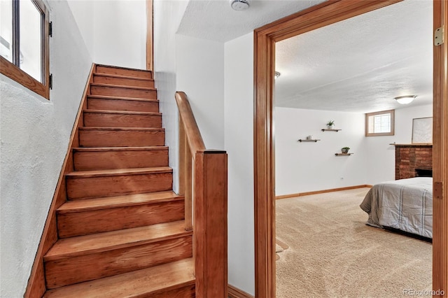 3611 N Vine St, Denver, CO 80205 - stairs featuring carpet, baseboards, a brick fireplace, and a textured wall