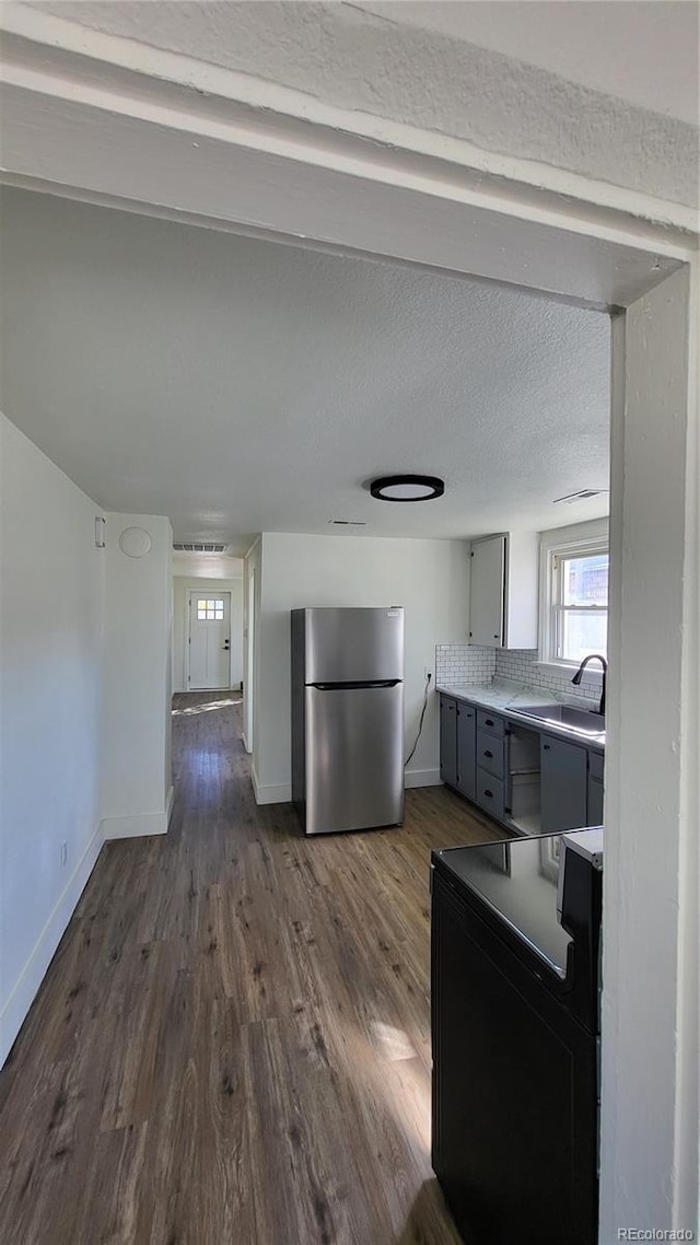 kitchen featuring electric stove, sink, dark wood-type flooring, stainless steel fridge, and gray cabinets