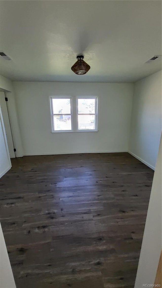 spare room featuring dark wood-type flooring