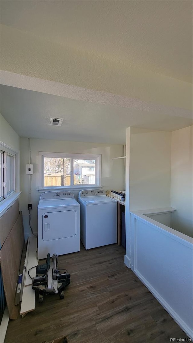 laundry room with washer and dryer, a textured ceiling, and dark wood-type flooring