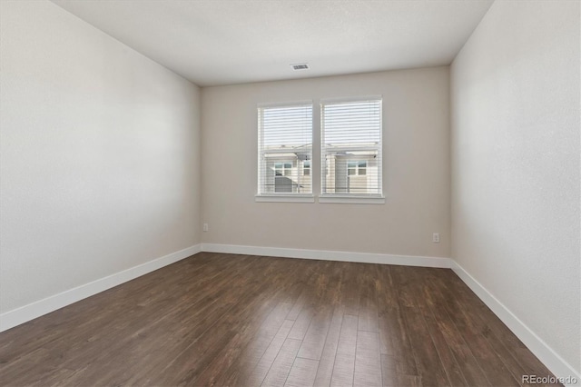 spare room with dark hardwood / wood-style flooring