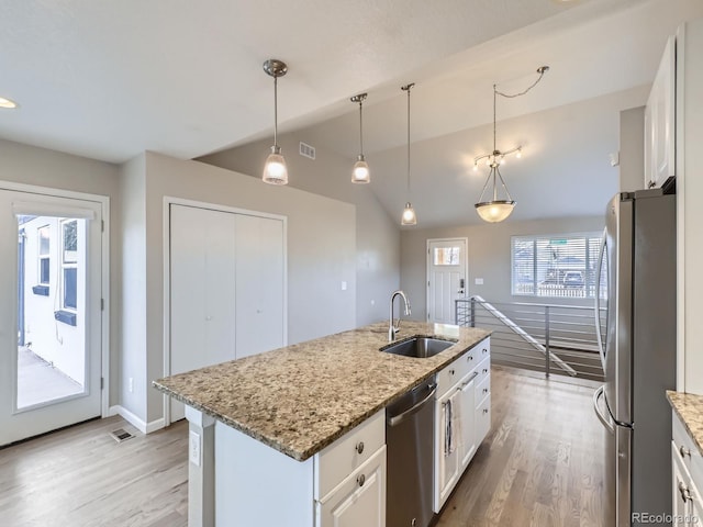 kitchen featuring white cabinets, appliances with stainless steel finishes, a center island with sink, and sink