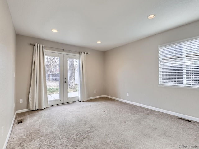 carpeted spare room with french doors