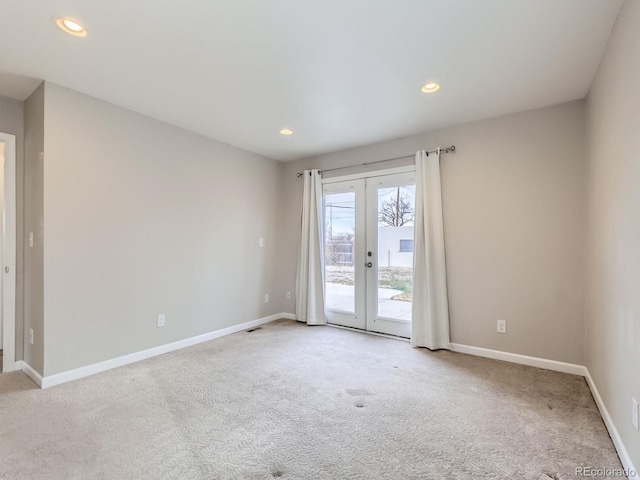 empty room featuring french doors and light colored carpet