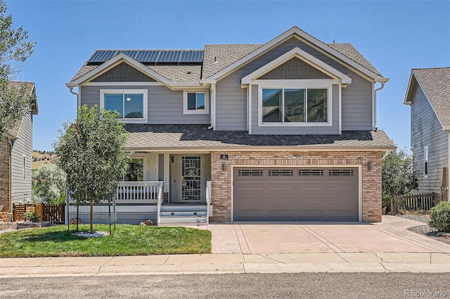 view of front of house featuring covered porch, solar panels, and a garage