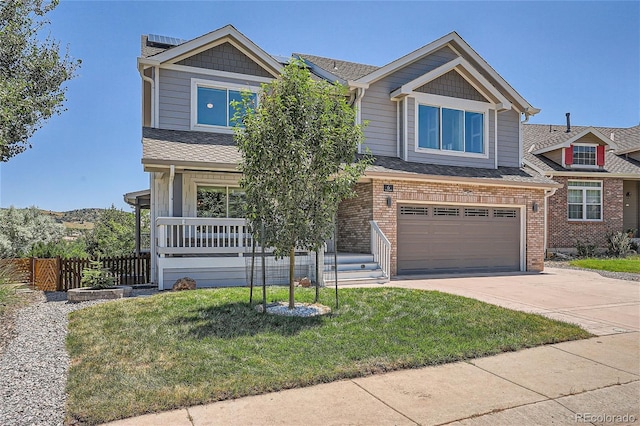 view of front of home featuring a porch, a garage, and a front lawn