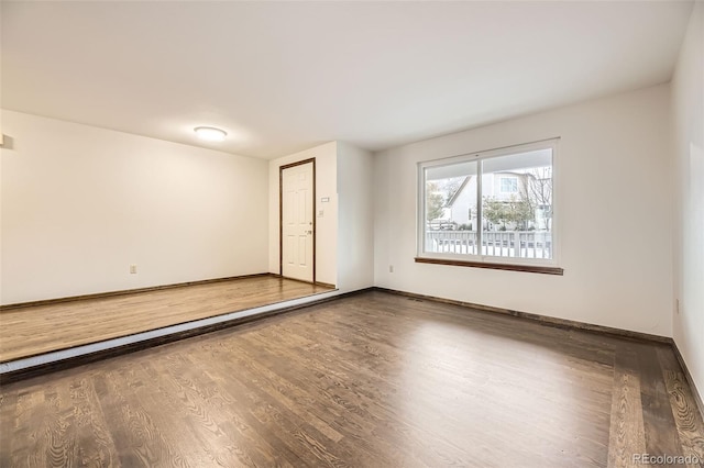 spare room featuring dark wood-type flooring