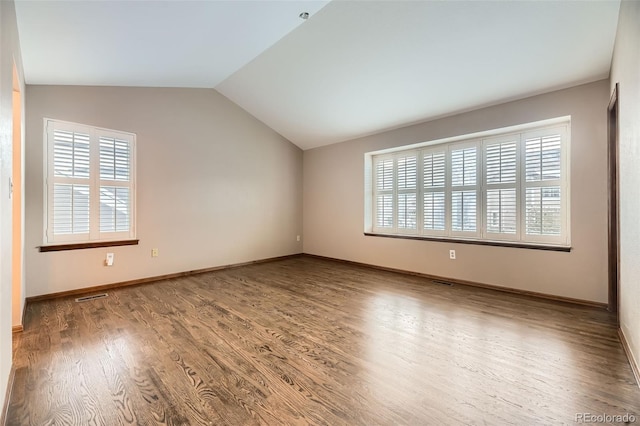 empty room featuring wood-type flooring and lofted ceiling