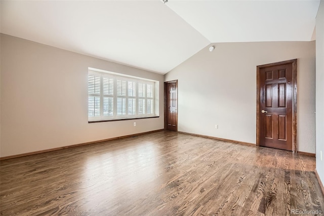 spare room with lofted ceiling and hardwood / wood-style flooring