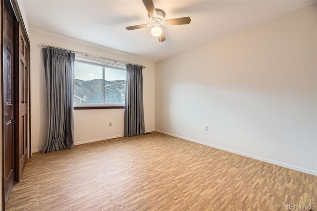 spare room with light wood-type flooring and ceiling fan