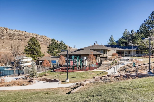 view of playground featuring a mountain view and a yard