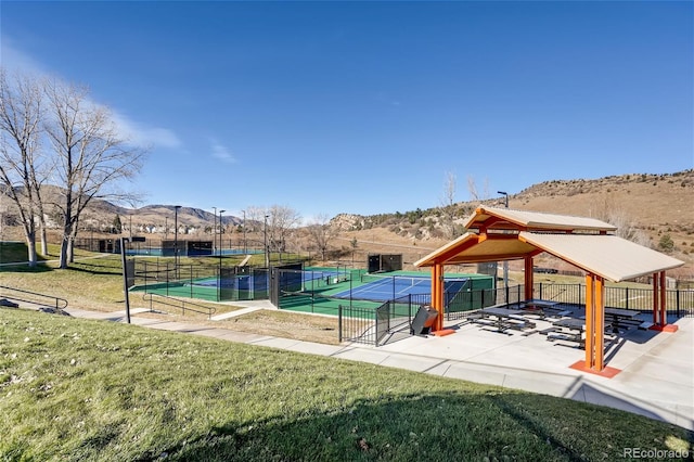 view of community featuring a gazebo, tennis court, a mountain view, and a lawn