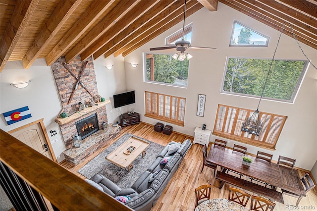 423 Prunes Pl, Fairplay, CO 80440 - living room with high vaulted ceiling, beam ceiling, wood finished floors, a fireplace, and a ceiling fan