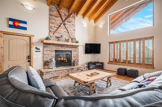 423 Prunes Pl, Fairplay, CO 80440 - living room featuring wooden ceiling with exposed beams, high vaulted ceiling, a stone fireplace, and wood finished floors