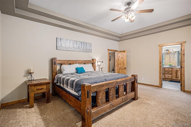 423 Prunes Pl, Fairplay, CO 80440 - bedroom featuring light colored carpet, baseboards, a tray ceiling, ensuite bathroom, and a ceiling fan