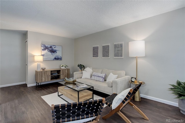 living room featuring wood finished floors, baseboards, and a textured ceiling